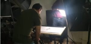 Photographers setting up tabletop product shoot indoors